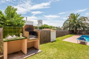 a backyard with a grill and a swimming pool at Villa Laurax in Son Carrio