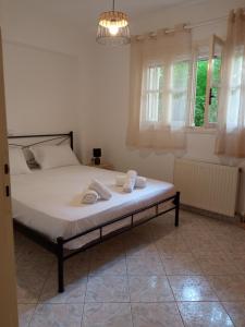 a bedroom with a bed with two towels on it at Veatriki Lefkada in Lefkada