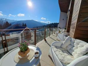 einen Balkon mit einem Sofa, einem Tisch und Aussicht in der Unterkunft The Rock in Sinaia