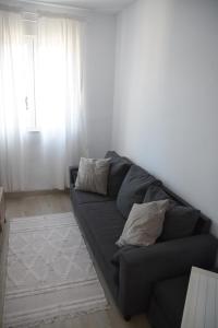 ein schwarzes Sofa im Wohnzimmer mit Fenster in der Unterkunft Nuevo apartamento en Santander! in Santander
