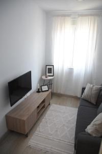 ein Wohnzimmer mit einem Flachbild-TV und einem Sofa in der Unterkunft Nuevo apartamento en Santander! in Santander