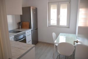 eine kleine Küche mit einem Glastisch und einem Fenster in der Unterkunft Nuevo apartamento en Santander! in Santander
