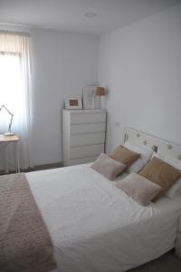 ein Schlafzimmer mit einem weißen Bett mit zwei Kissen in der Unterkunft Nuevo apartamento en Santander! in Santander