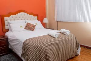 a bedroom with a bed with two towels on it at Baños del. Inca in Lima