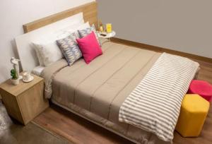 ein großes Bett mit Kissen darauf in einem Zimmer in der Unterkunft Baños del. Inca in Lima