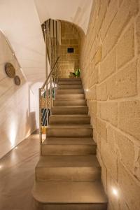una escalera en una pared de ladrillo con una escalera en Mazzini Accommodation, en Favignana