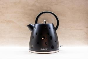 a black tea kettle sitting on a table at Steni Traditional Studio Apartment in Paphos