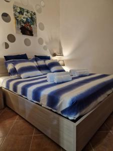een groot bed met blauwe kussens erop bij Apartament Luna in Carini