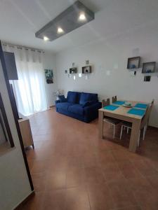 een woonkamer met een blauwe bank en een tafel bij Apartament Luna in Carini