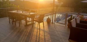 アルガッシにあるArgassi Hilltop Villaのパティオ(日没の景色を望むテーブル、椅子付)