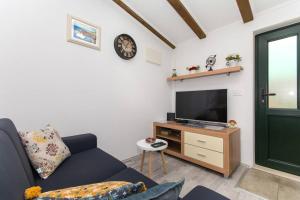 a living room with a couch and a tv at Sweet Studio with terrace in Dubrovnik