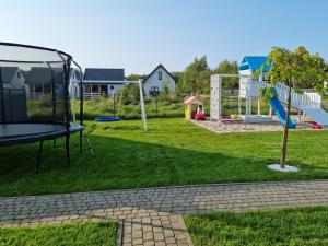 a park with a playground with a slide at domki letniskowe ŚWIĘTY SPOKÓJ in Rusinowo