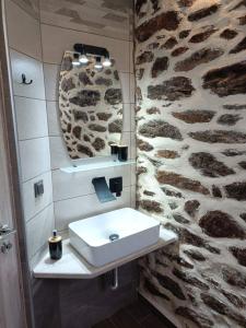 a bathroom with a sink and a stone wall at Chalkidiki AsterGia apartments in Metangítsion