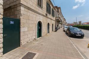 a building with a green door on the side of a street at Sweet Studio with terrace in Dubrovnik