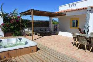 einen Whirlpool auf einer Terrasse mit einem Tisch und Stühlen in der Unterkunft Casa do Livramento in Luz de Tavira