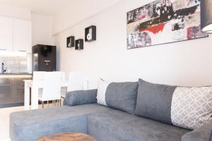 uma sala de estar com um sofá azul e uma cozinha em SKG Dream Residence em Tessalônica