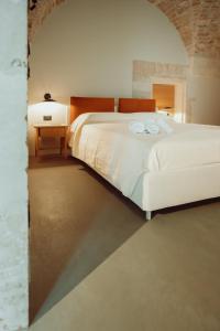 Un dormitorio con una gran cama blanca y una mesa. en Palazzo Le Marangi, en Martina Franca 21 fotos más