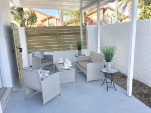 un patio con sillas de mimbre, mesa y banco en Modern & New,Excellent Location Miami en Miami