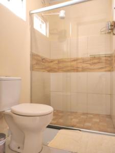 a bathroom with a toilet and a shower at Chalé com ar condicionado e garagem in Alto Paraíso de Goiás
