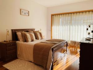 a bedroom with a large bed and a window at Viseu Home in Viseu