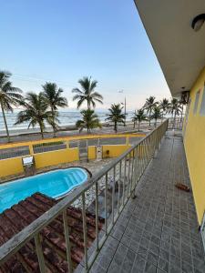 a view of the beach from the balcony of a resort at Hostel Encanto de Mongaguá in Mongaguá