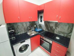 a small kitchen with red cabinets and a washing machine at Άνετο στούντιο στο κέντρο in Athens