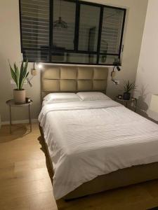 1 dormitorio con 1 cama blanca grande y ventana en חדר סטודיו בסגנון נורדי en Sede Naẖum