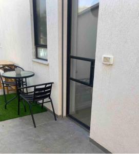 patio con mesa, silla y ventana en חדר סטודיו בסגנון נורדי en Sede Naẖum