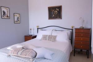 Schlafzimmer mit einem Bett mit weißer Bettwäsche und Kissen in der Unterkunft Villa Angelina in Pesádha