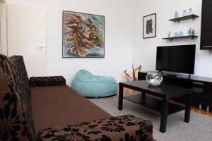 ein Wohnzimmer mit Sofa und Flachbildfernseher in der Unterkunft Apartment Stella Marina in Rabac