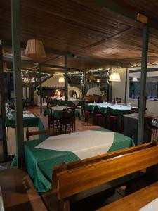 un ristorante con tavoli e sedie verdi in una stanza di Hotel La Torricella a Capalbio
