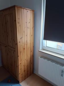 a room with a wooden cabinet next to a window at Nette Kuschelige Wohnung in Bochum