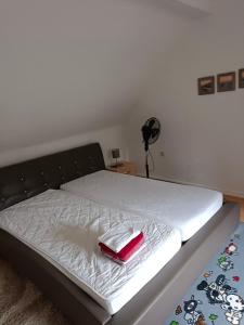 a bed with a red item on top of it at Nette Kuschelige Wohnung in Bochum