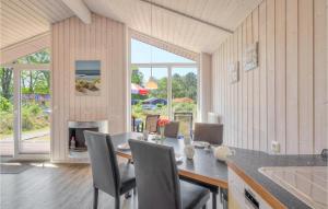 a dining room with a table and chairs and a large window at Schatzkiste 9 - Dorf 4 in Travemünde