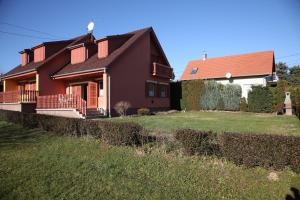 a brown house with a red roof and a yard at Edina Apartman in Zalakaros
