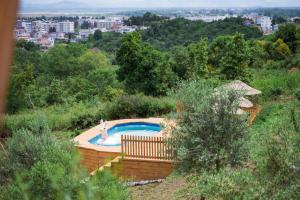a swimming pool in a hill with a city in the background at Madre Natura Glamping in Ulcinj