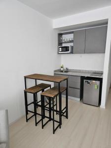 a kitchen with a table and stools in a room at LaMari in Buenos Aires