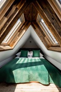 Un dormitorio con una cama verde en un ático en Widokowa Villa TOP - ADULTS ONLY, en Kościelisko