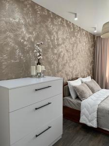 een slaapkamer met een wit dressoir en een bed bij Apartment Guli in Tasjkent