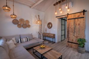 a living room with a couch and a wooden door at Chora Suite in Alonnisos Old Town