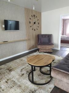 ein Wohnzimmer mit einem Tisch und einem Sofa in der Unterkunft Apartment Guli in Taschkent
