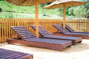 three lounge chairs and umbrellas on a deck at Madre Natura Glamping in Ulcinj