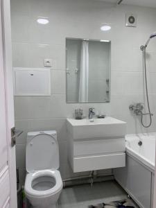 ein Badezimmer mit einem WC, einem Waschbecken und einer Badewanne in der Unterkunft Apartment Guli in Taschkent