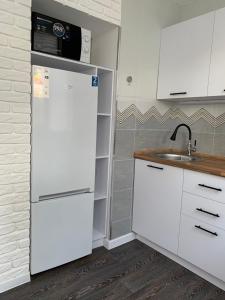 eine Küche mit einem weißen Kühlschrank und einer Spüle in der Unterkunft Apartment Guli in Taschkent
