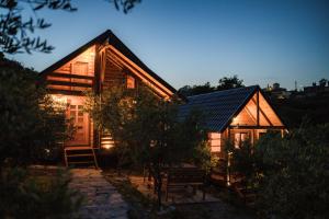 duży drewniany dom z dachem słonecznym w nocy w obiekcie Madre Natura Glamping w Ulcinju