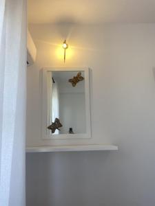 a mirror with a butterfly on a white wall at Harmony Seaside Pelion in Platanias