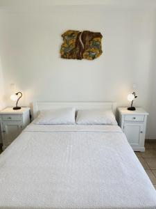 a bedroom with a white bed with two night stands at Harmony Seaside Pelion in Platanias