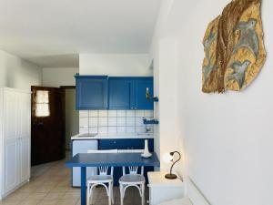 a blue kitchen with a blue table and stools at Harmony Seaside Pelion in Platanias