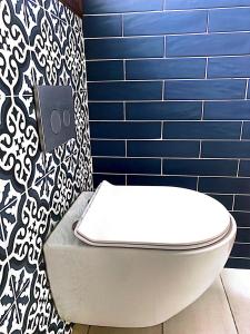 a white toilet in a bathroom with a blue wall at Harmony Seaside Pelion in Platanias