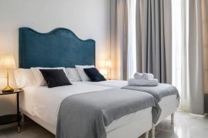 a bedroom with a large bed with a blue headboard at San Buenaventura Apartment 13 in Seville